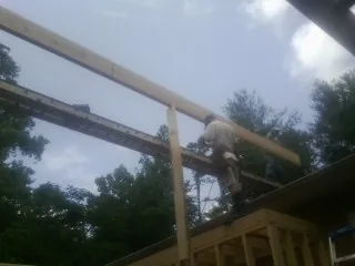 Carpenter setting a ridge beam over a new addition frame — Ice Dam Removal by Roofing Brothers in Orchard